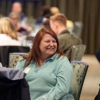 person laughing at luncheon table